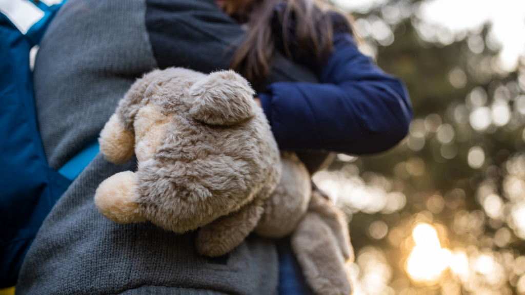 A young child holding their favorite toy during a family photo session for comfort. 