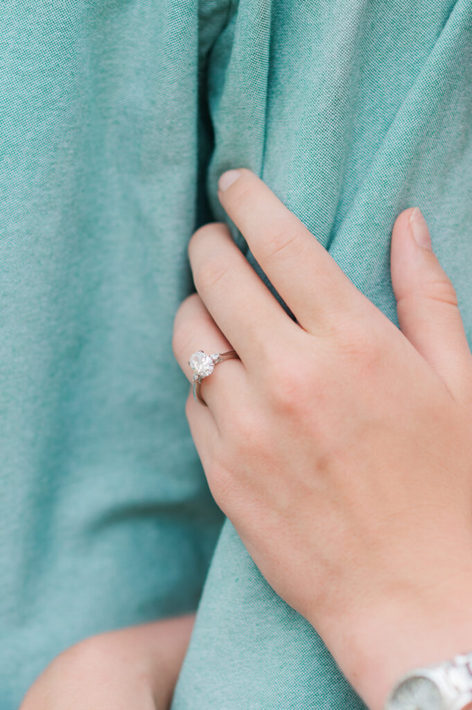 Close-up of Aubrey's engagement ring resting on Nolan's shirt during their Emerald Coast engagement session in the Florida Panhandle.