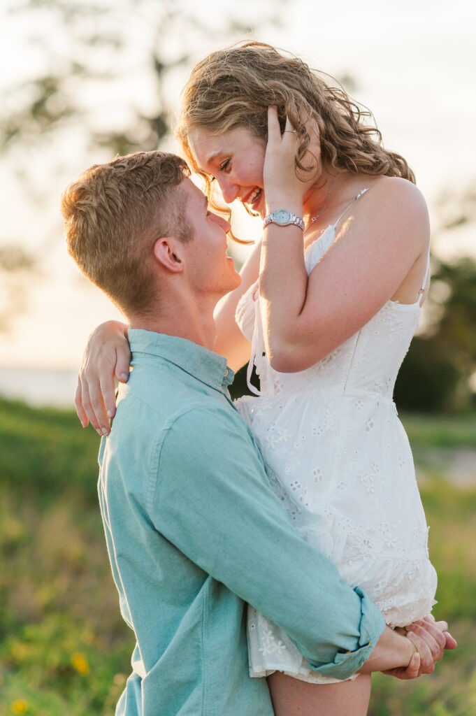 Couple laughing together while embracing during an outdoor engagement session in Florida's Emerald Coast Panhandle.