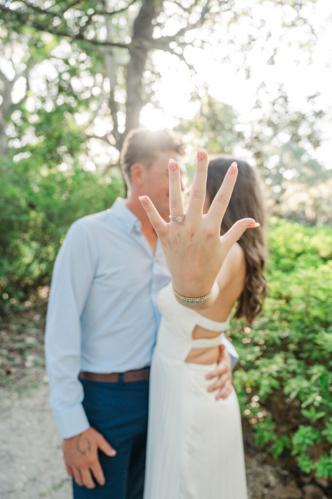 Bride-to-be showing her engagement ring during a sunset engagement session at Eden Gardens State Park in Santa Rosa Beach.